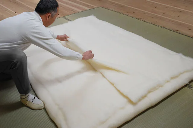 Eine Baumwolldecke wird von Hand aufgeschichtet